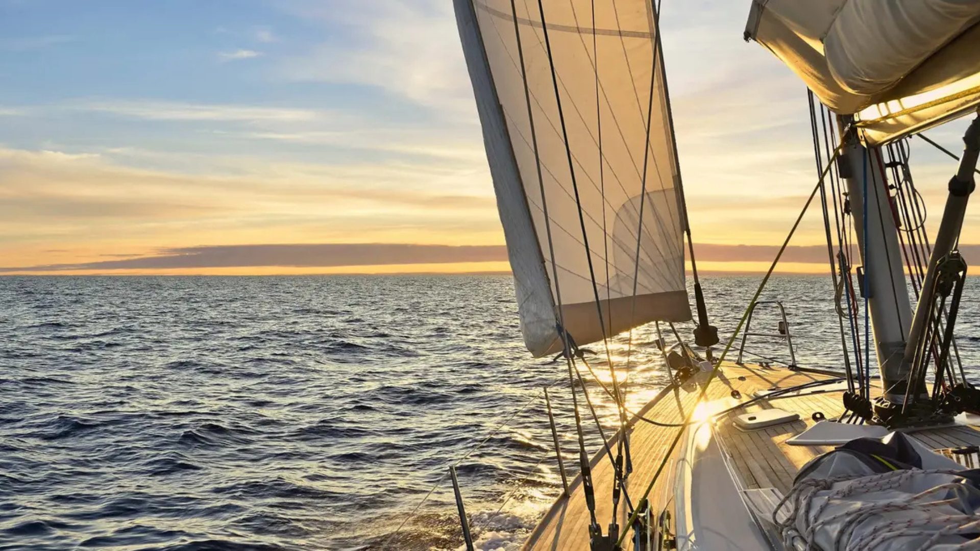 Sailboat under full sail at sunset