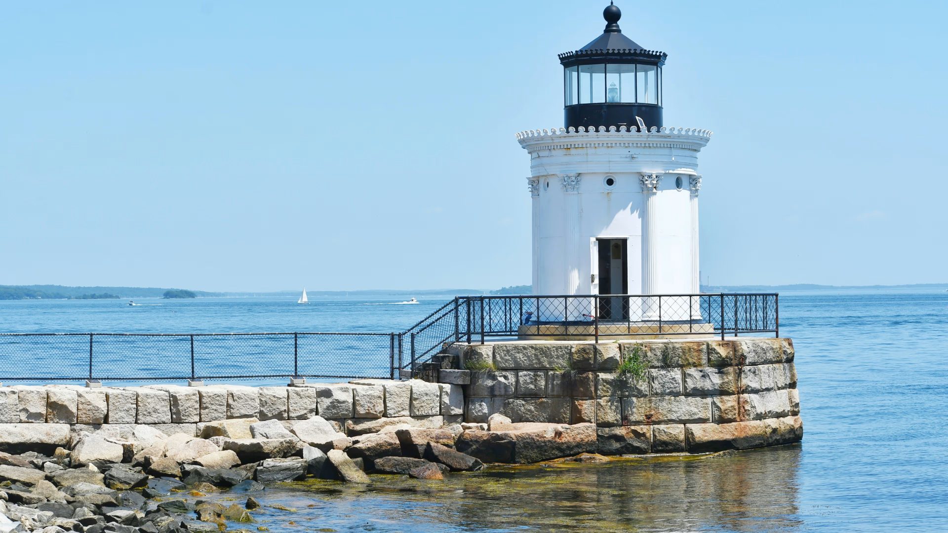 White lighthouse on a granite breakwater overlooking the sea